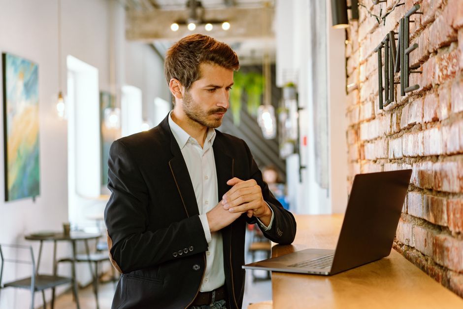 Property manager in a suit reviewing reservations on a laptop